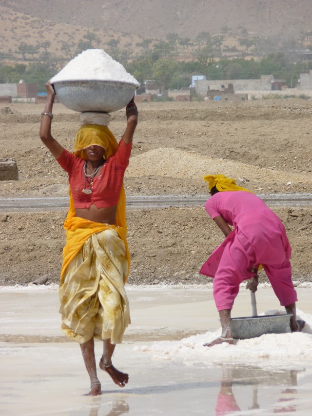 Two girls working on the desolate burning salt plains.