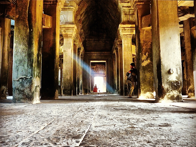 Young vagabond stands in the Temple of Angkor Wat, Cambodia